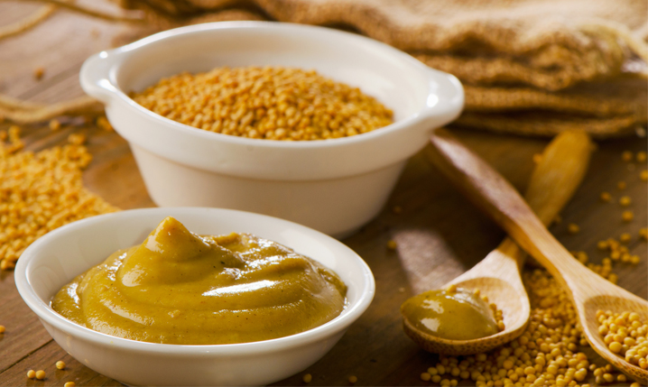 a bowl of mustard sauce and a bowl of mustard seeds