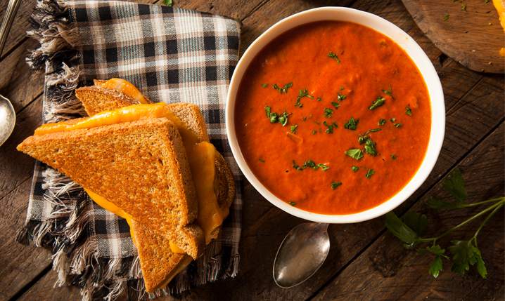 tomato soup next to a grilled cheese sandwich